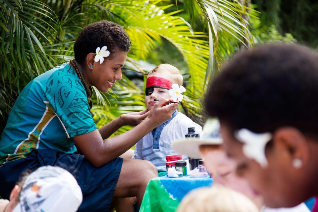 Outrigger Fiji Beach Resort Korotogo Luaran gambar A young woman from the Cook Islands applying titi muka to a child's face